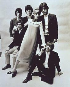 Patti_Boyd_in_a_MQ dress between the Rolling Stones