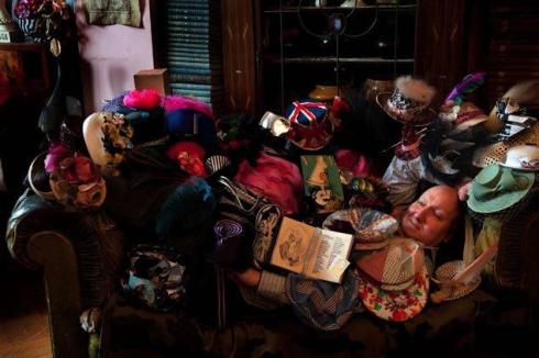 Stephen Jones between a collection of hats he made for Anna Piaggi